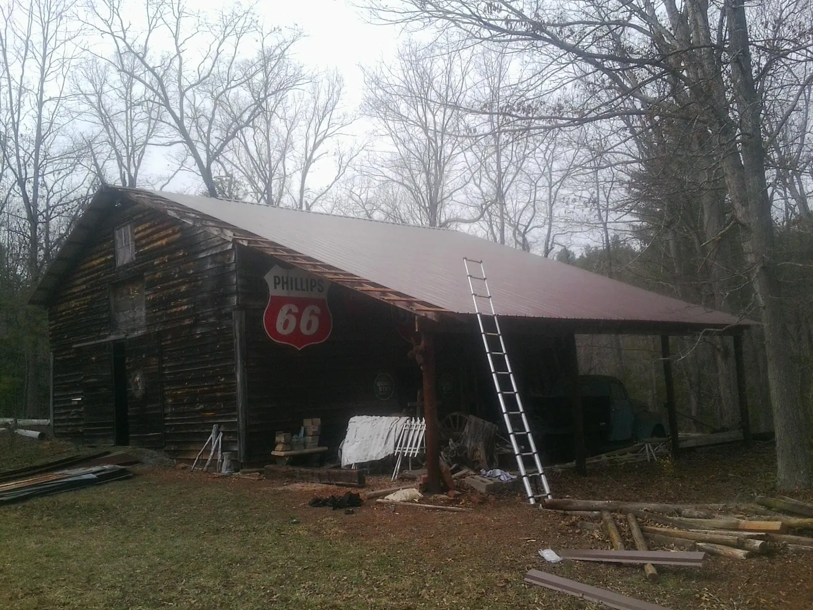 New metal roof on an open sided timber barn with a vintage sign in Lakeville